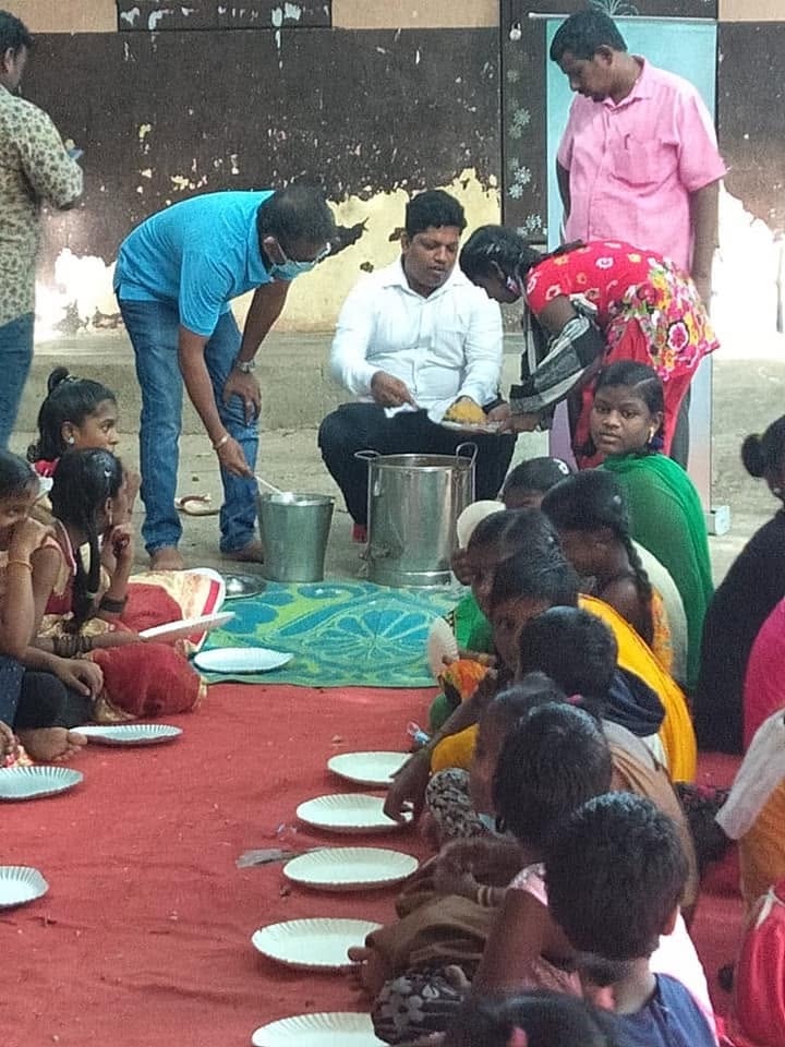 A volunteer serving a meal to children